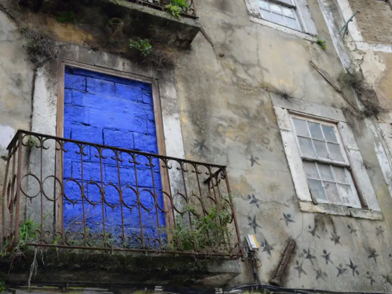 Dein Lissabon Sehenswürdigkeiten Rundgang wird dich dank meiner Lissabon Tipps auch an verlassenen Häusern wie diesem mit einer blauen Balkontür versehenen vorbeiführen.