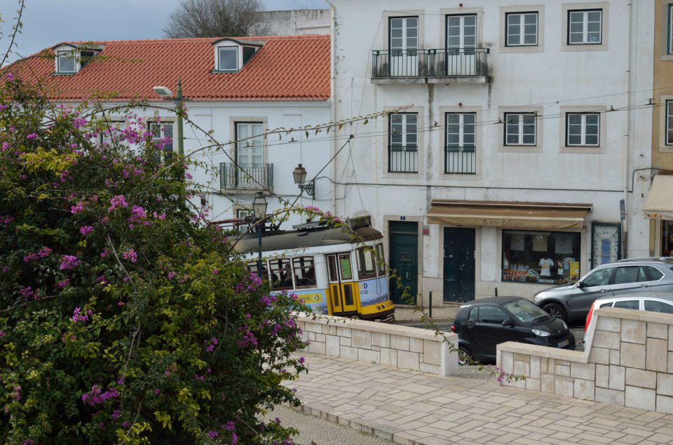 Die berühmte Straßenbahn 28E verbindet mehrere der Lissabon Sehenswürdigkeiten. Hier passiert sie den Miradouro de Santa Luzia.