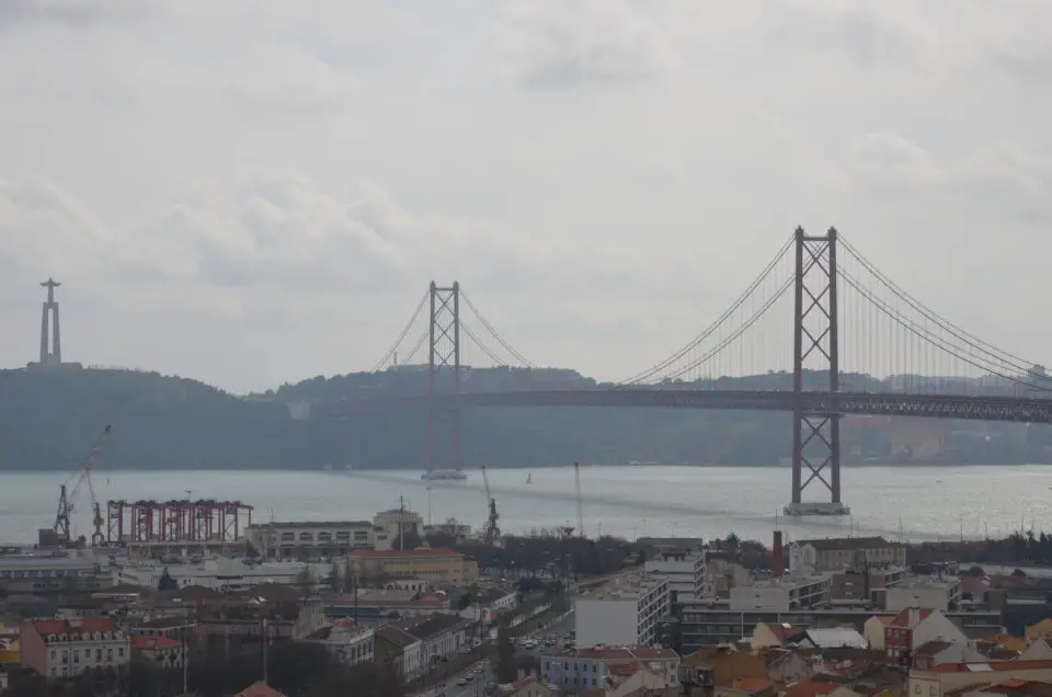 Ponte 25 de Abril und Santuario Nacional de Cristo Rei im Westen von Lissabon vom Cemitério dos Prazeres aus gesehen.